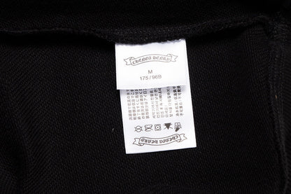 Sweat-shirt noir à motif de cœurs chromés, coulures de peinture et croix jaune.