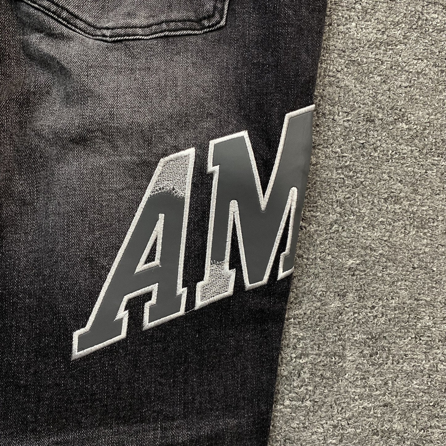 AMIRI VARSITY LOGO REPAIR JEANS
